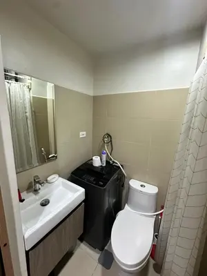 a bathroom with a white toilet and a sink at Gateway Mall of Asia Near Airport in Manila
