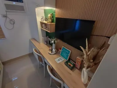 a wooden table with two chairs and a television at Naomi's Green Haven in Dasmariñas