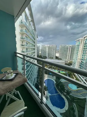 a balcony with a view of a pool and buildings at Azure staycation in Manila