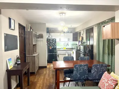 a kitchen and living room with a table and chairs at Comfortable 1BR Pasig Apartment in Manila