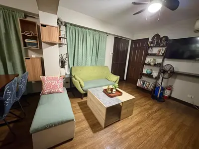 a living room with a couch and a table at Comfortable 1BR Pasig Apartment in Manila