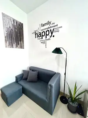 a blue couch in a living room with a happy wall at SELF CHECK-IN Near La Salle Dasma in Dasmariñas
