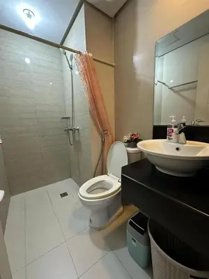 a bathroom with a shower and a toilet and a sink at Sleep and Fly Condotel in Manila
