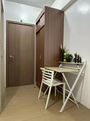 a table and a chair in a room with a door at Sleep and Fly Condotel in Manila