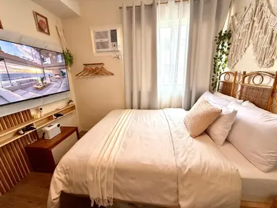 a bedroom with a bed and a tv in it at A'more Cosy Stay Near Nuvali at Fullerton Suites in Silang
