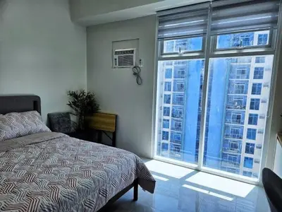 a bedroom with a bed and a large window at MANILA AIR RESIDENCE 24 floor in Manila