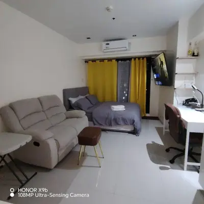 a living room with a couch and a bed at Sozy Cozy Knightsbridge Residences 1 in Manila