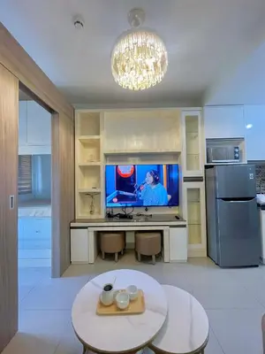a kitchen with a tv and a table in a room at Cozy condo unit in Manila