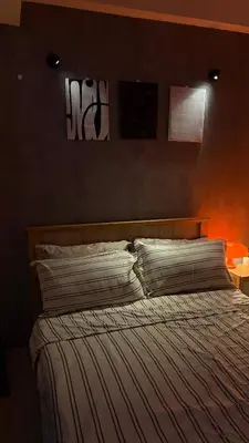 a bedroom with a bed with an orange wall at Rosé Nights Luxury in Manila