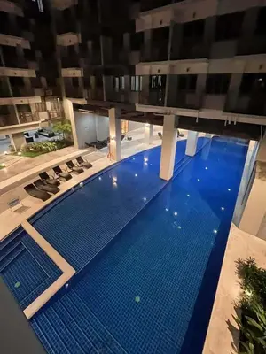 a large swimming pool in a building with a blue floor at Calm Corner near Mall of Asia in Manila