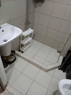 a white bathroom with a sink and a shower at Staycation Marcos Residence in Manila