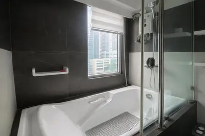 a bathroom with a bath tub and a window at Stylish Stay in BGC 5th Ave with Free Parking in Manila