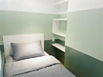 a small bedroom with a bed and shelves at Stylish Stay in BGC 5th Ave with Free Parking in Manila