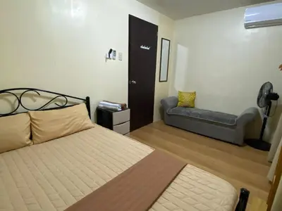 a bedroom with a bed and a couch in it at 1BR Cozy Townhouse - AC in room only in General Trias