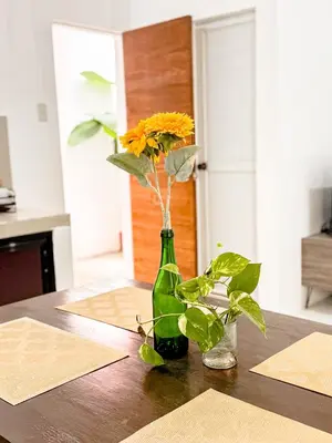 a green bottle with flowers in it on a table at LAD Private Reosrt in Dasmariñas