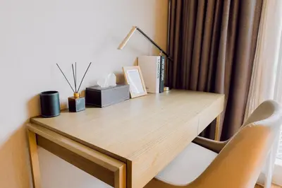 a wooden desk with a lamp and a chair at Primo Espacio at Hotel Residences Acqua in Manila