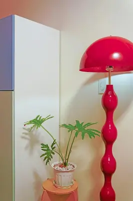 a red lamp sitting on a table with a potted plant at Airhaus Studio in Manila