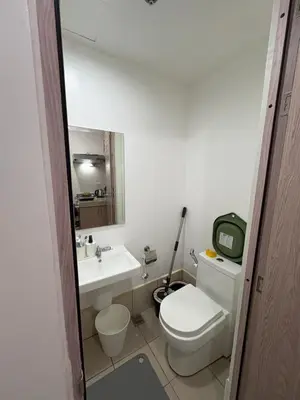 a bathroom with a white toilet and a sink at Katya Suite in Pasong Bayog
