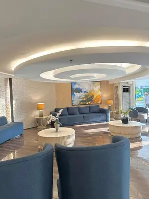 a living room with a couch and tables and chairs at Shell Residences MOA by Seph in Manila