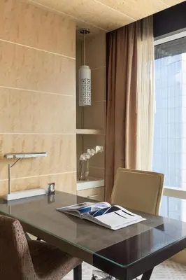 a desk in a room with a table and chairs at Shangri-La The Fort, Manila in Manila