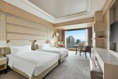 two beds in a hotel room with a view at Shangri-La The Fort, Manila in Manila