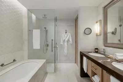 a bathroom with a shower and a tub and a sink at Shangri-La The Fort, Manila in Manila