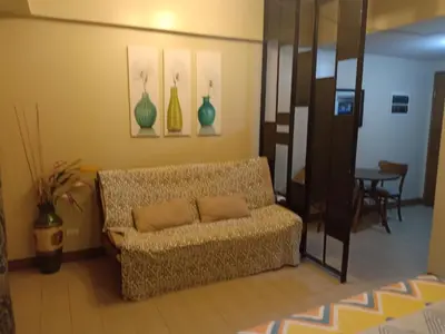 a living room with a couch and a table at Palm Tree Genlex Condo in Manila