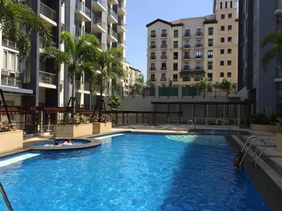a swimming pool in the middle of a building with buildings at Love This Place in Manila