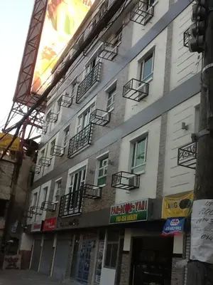 a tall building with windows and balconies on a street at AAM Transient and Guest House in Manila