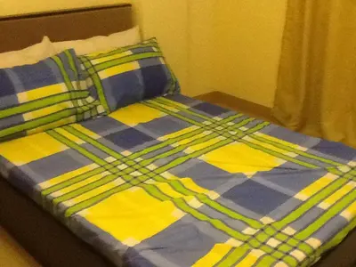 a bed with a blue and yellow blanket and pillows at AAM Transient and Guest House in Manila