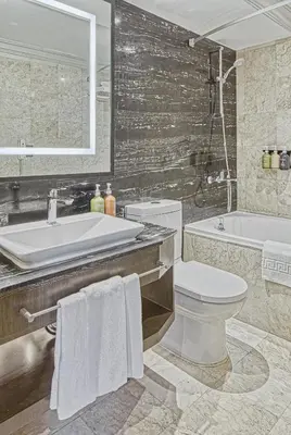 a bathroom with a sink and a toilet and a tub at Holiday Inn & Suites Manila Galleria by IHG in Manila