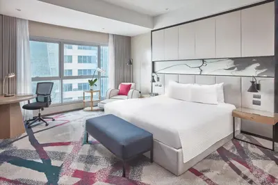 a hotel room with a bed and a desk and a chair at Crowne Plaza Manila Galleria by IHG in Manila
