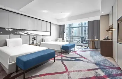 a hotel room with two beds and a desk at Crowne Plaza Manila Galleria by IHG in Manila