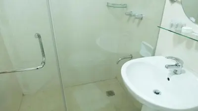 a bathroom with a shower and a toilet and a sink at Avant Serviced Suites - Personal Concierge in Manila