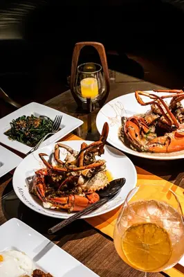 a table with three plates of seafood and a glass of wine at Shangri-La Residences The Fort, Manila in Manila