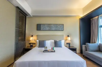 a bedroom with a large white bed and a couch at I'M Hotel in Manila