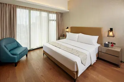 a bedroom with a large bed and a blue chair at I'M Hotel in Manila