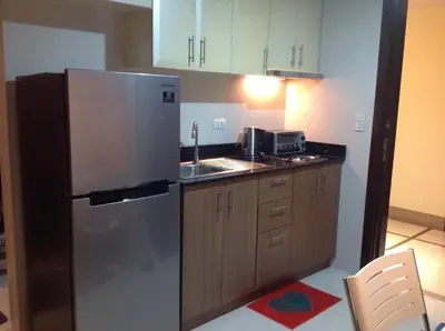 a kitchen with a stainless steel refrigerator and a sink at Palm Tree Villas by Ann in Manila