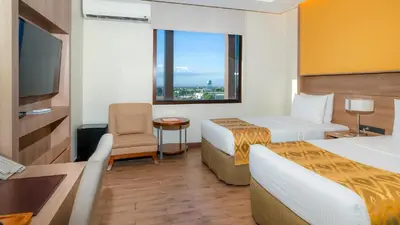 a hotel room with two beds and a window at The Bayleaf Cavite in General Trias