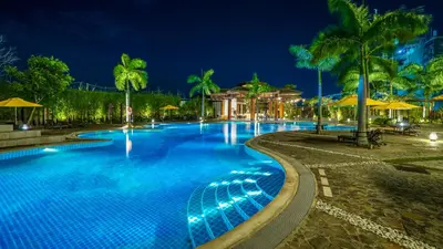 a large swimming pool at night with palm trees at The Bayleaf Cavite in General Trias