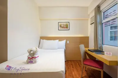 a hotel room with a bed and a desk at MySpace Hotel @BGC in Manila