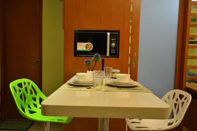 a kitchen with a table with chairs and a microwave at A Homey Place At Adriatico in Manila
