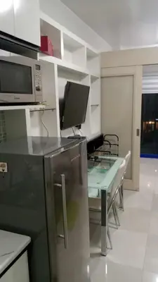 a kitchen with a table and a microwave at Anna's Place at Sea Residences in Manila