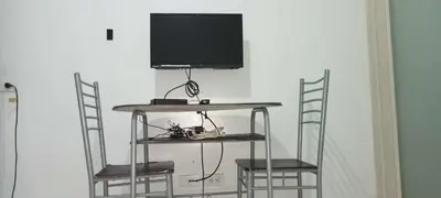 a tv sitting on top of a table with two chairs at Anna's Place at Sea Residences in Manila