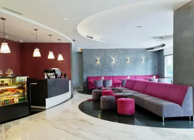 a lobby with a pink couch and a bar at Wynwood Hotel in Manila