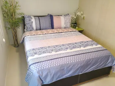 a bed in a room with purple sheets and pillows at All At Jazz - Makati Serviced Apartments in Manila