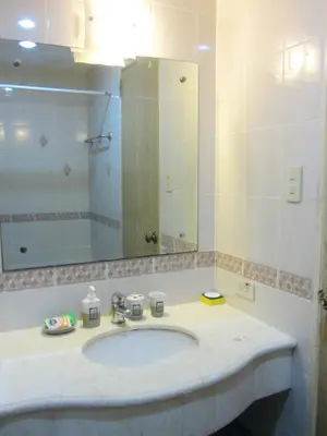 a bathroom with a sink and a large mirror at Baywatch Tower in Manila