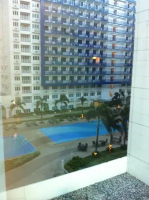 a view of a large building from a window at Sea Residences MOA-Eric Apartments in Manila