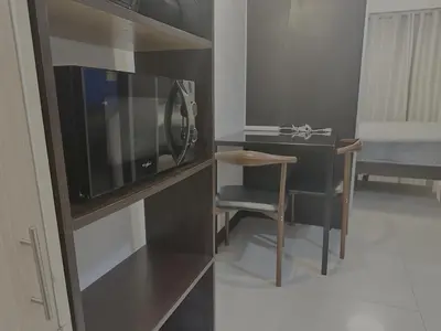 a room with a microwave and a table and a bed at SweetSuites at Pine Crest #T3-1212 in Manila