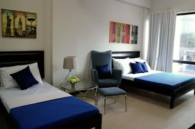 a hotel room with two beds and a chair at Ortigas Budget Hotel - Kapitolyo in Manila